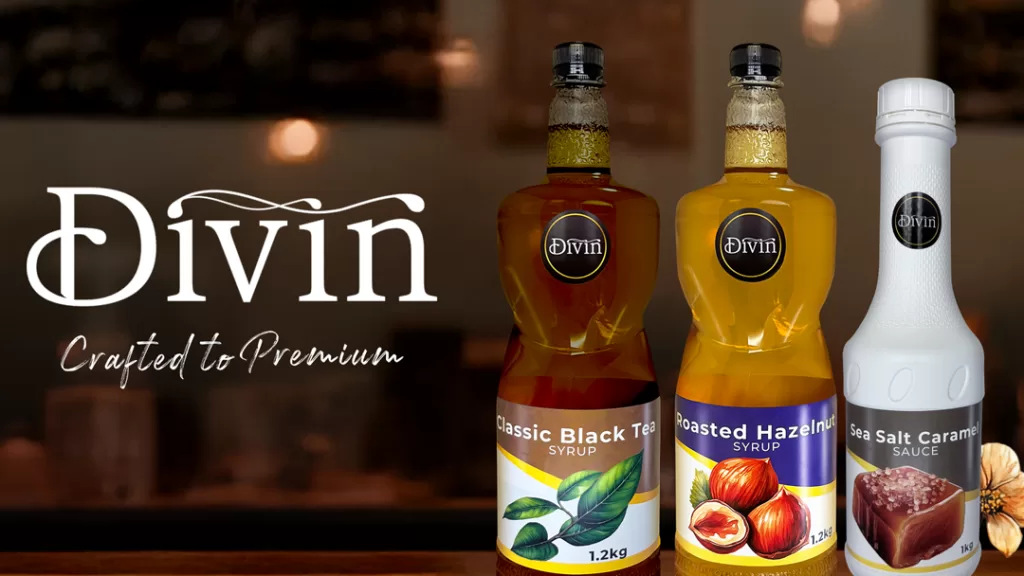 Divin’s featured syrup and sauce products: Classic Black Tea, Roasted Hazelnut, and Sea Salt Caramel, displayed with the Divin logo and tagline “Crafted to Premium” on a warm café-style background.
