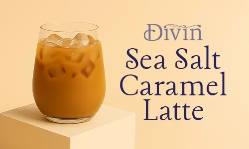 a glass of iced sea salt caramel latte placed on a podium with a plain beige background
