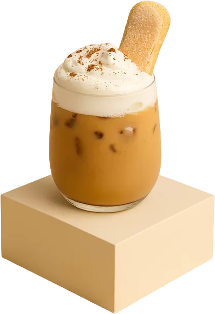 A glass of iced tiramisu latte topped with cream cheese foam, cocoa powder, and a ladyfinger biscuit on a beige podium.