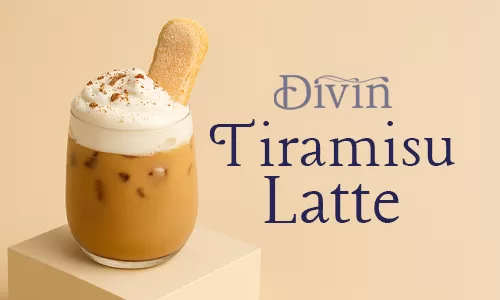 A glass of iced tiramisu latte topped with cream cheese foam, cocoa powder, and a ladyfinger biscuit beside the text “Divin Tiramisu Latte.